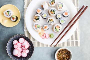 a plate of sushi with chopsticks