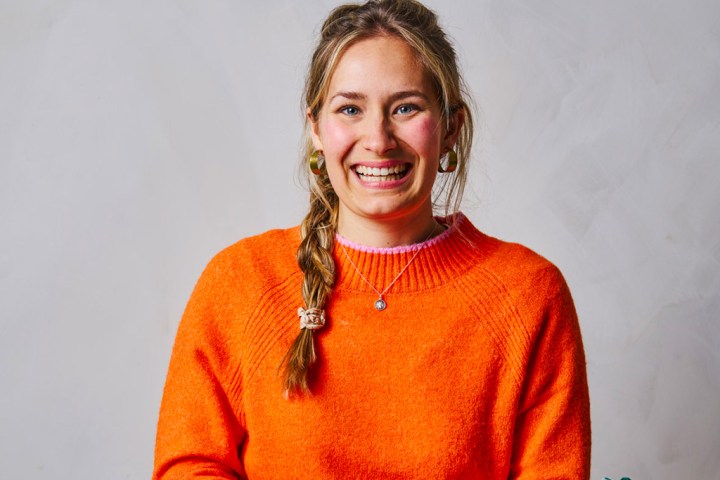 a person smiling and wearing orange shirt