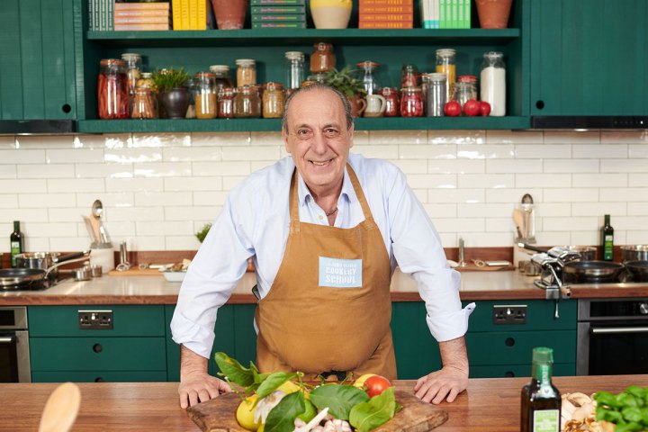 Gennaro Contaldo sitting on a kitchen counter