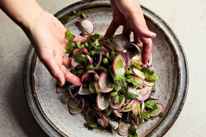 a person holding a plate of food with broccoli