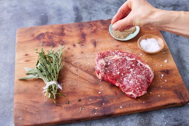 a slice of pizza sitting on top of a wooden cutting board