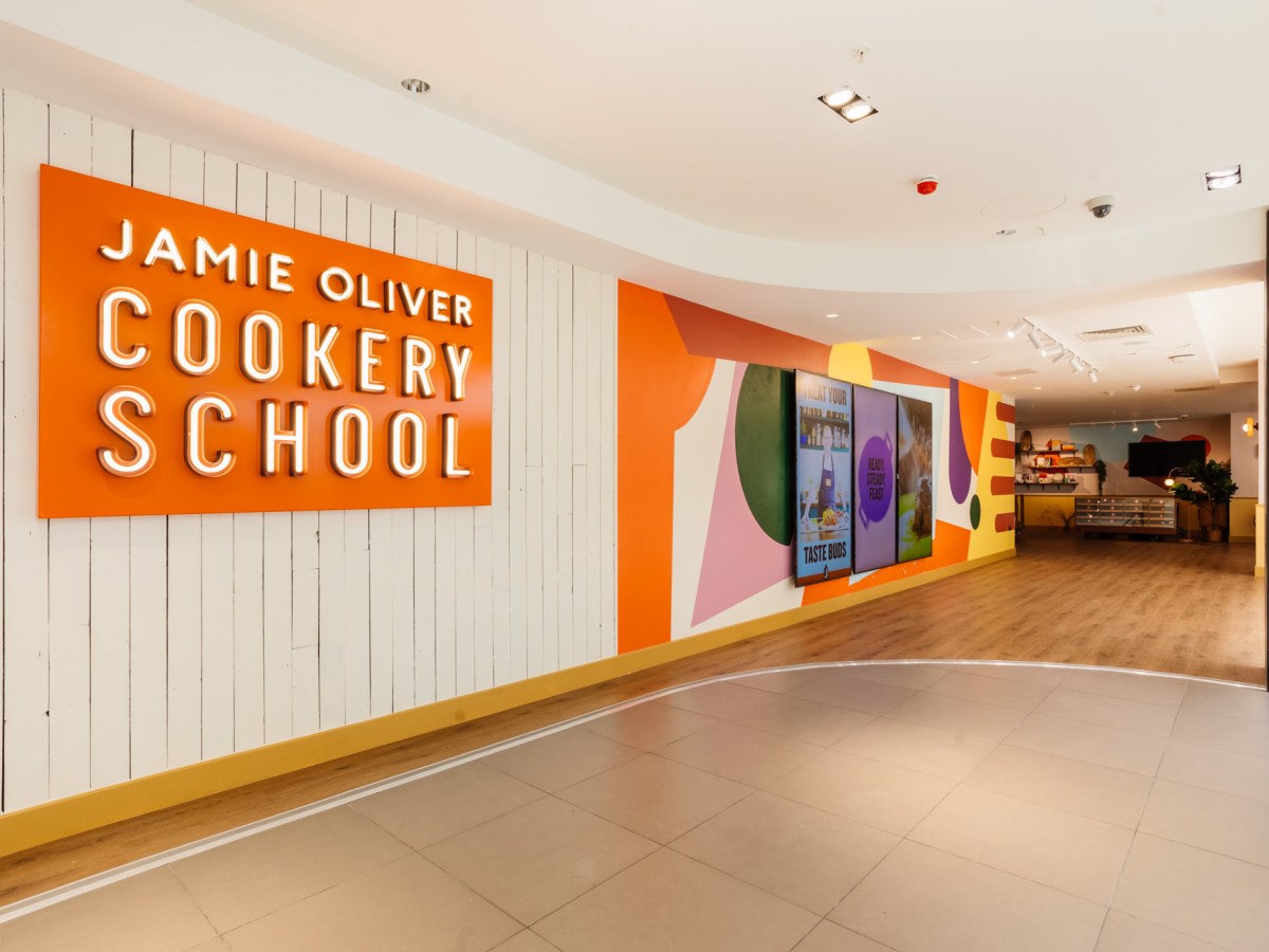web__001__jamie-oliver-cookery-school-launch a room that has a sign on the floor