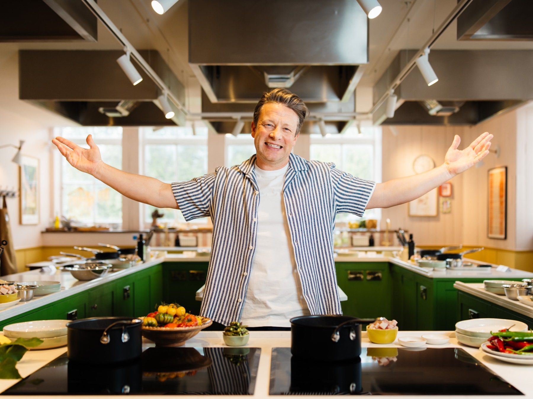 Jamie Oliver and woman preparing food in a kitchen