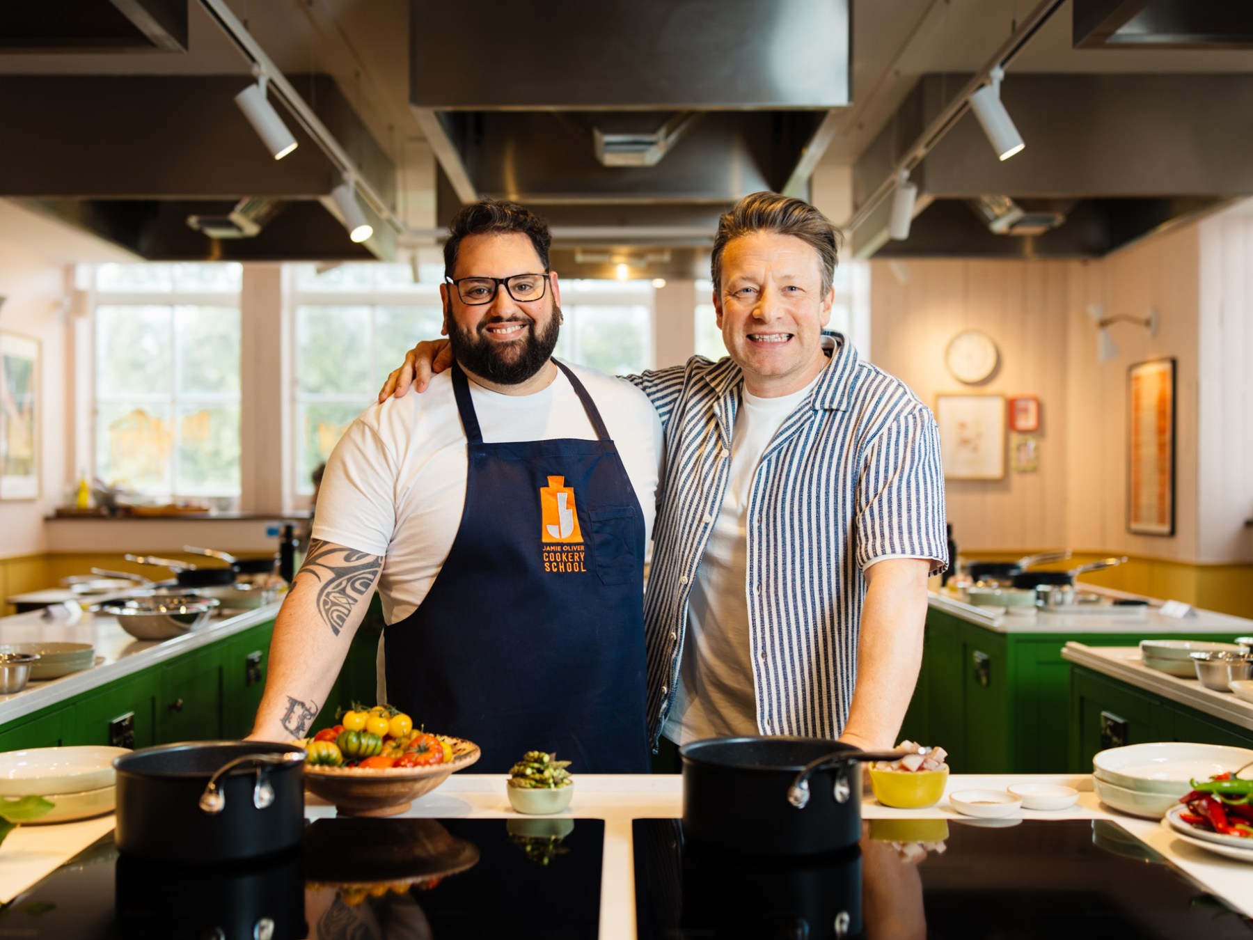Jamie Oliver standing in a kitchen preparing food