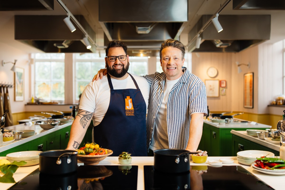 web__006__jamie-oliver-cookery-school-launch Jamie Oliver standing in a kitchen preparing food