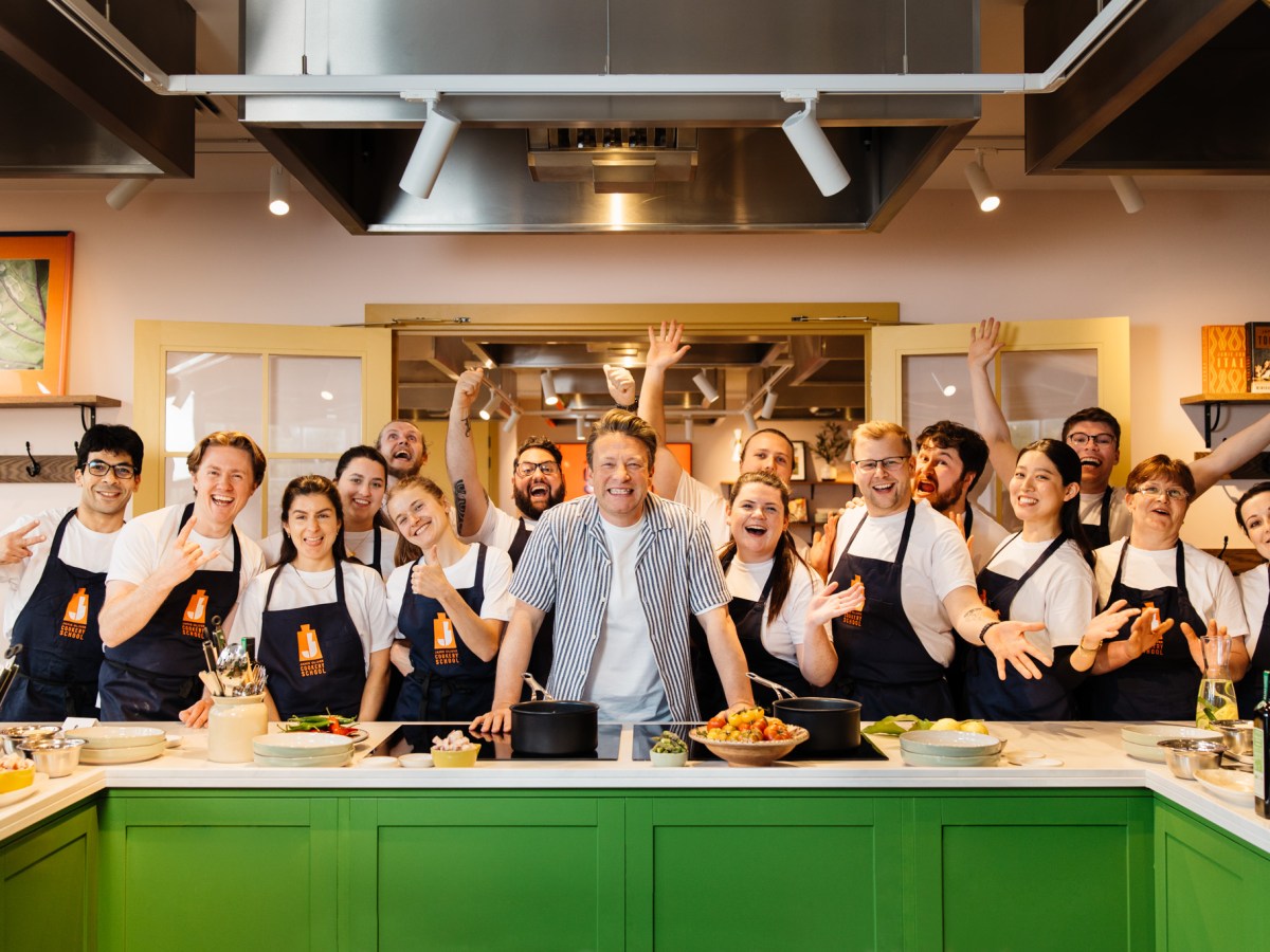 Jamie Oliver et al. standing in a kitchen