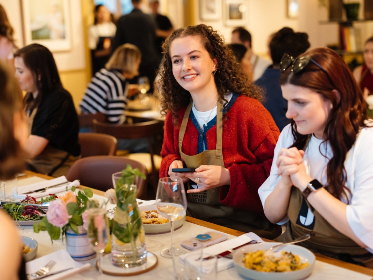 Group of people enjoying a meal together at a decorated table in a cozy restaurant setting.