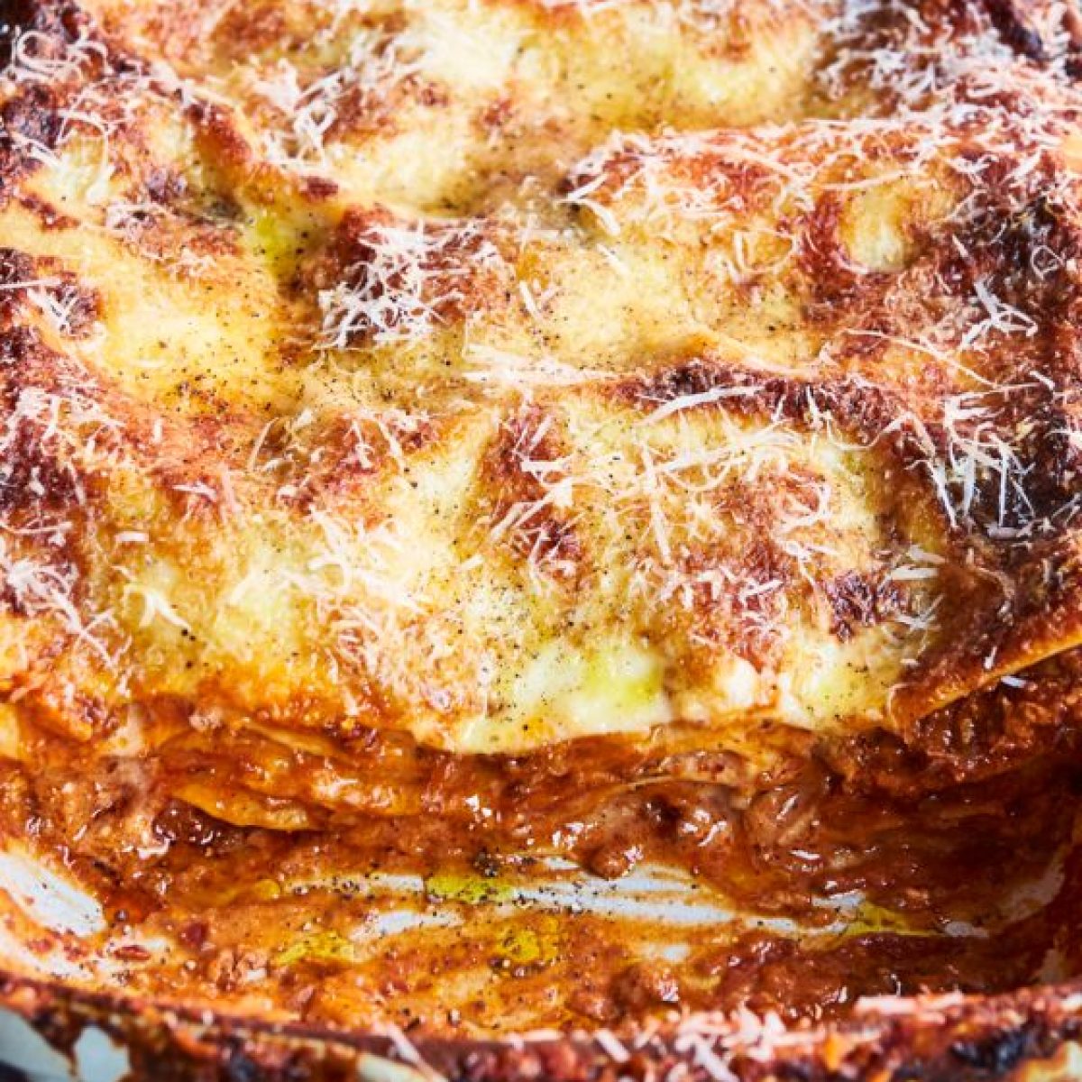 Lasagne_24 A freshly baked lasagna with one slice removed in a white baking dish.