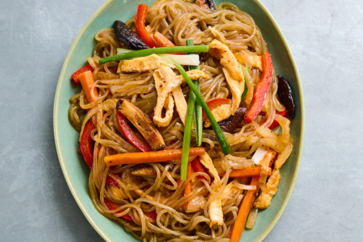 A plate of stir-fried noodles with vegetables and chicken.